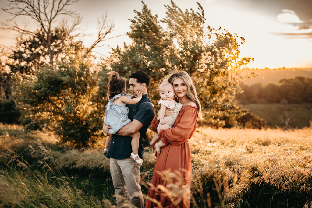family standing in field during golden hour