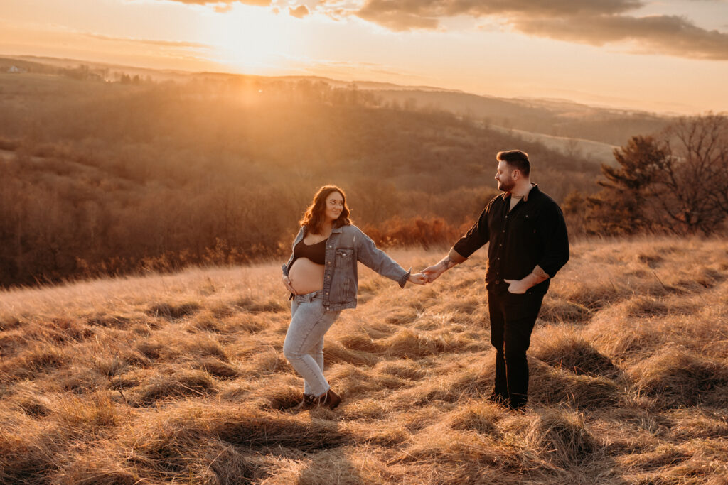 maternity session at golden hour, picture of mom and dad on hill