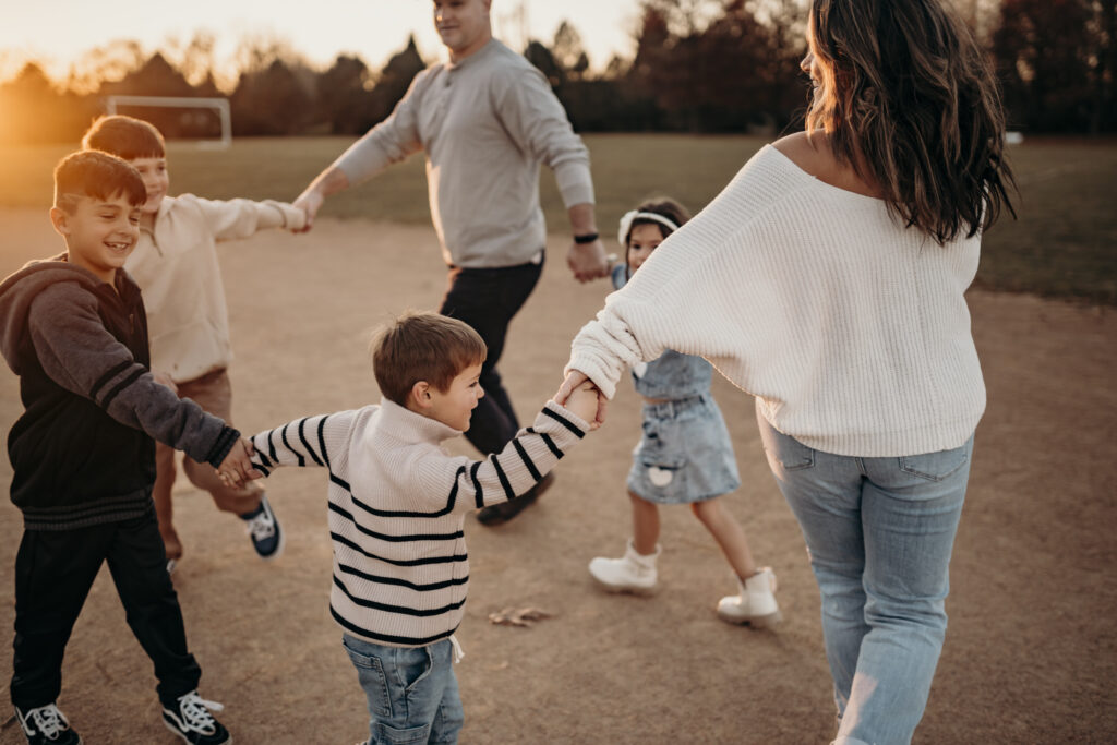 family holding hands during sunset