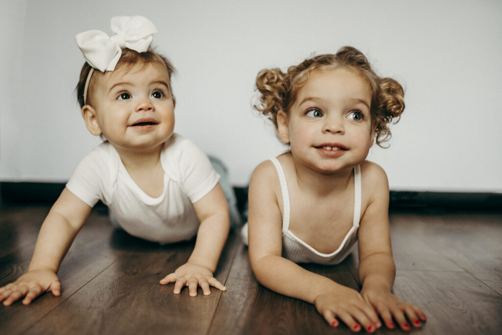 sister photoshoot laying on ground
