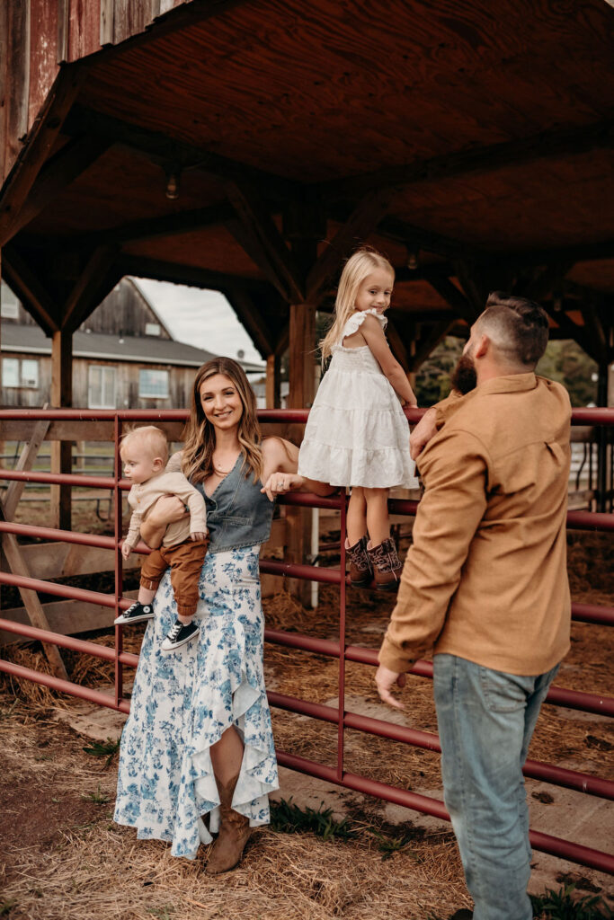 family on fence at farm in PA during photoshoot