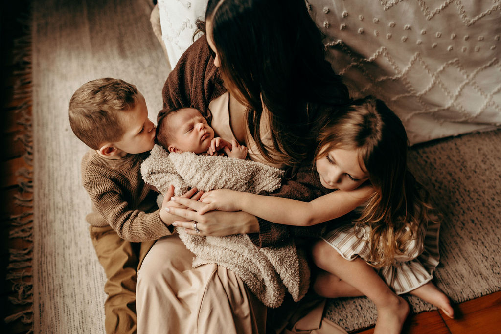 mom with children sitting on floor during newborn photoshoot, maternity and newborn photography package.