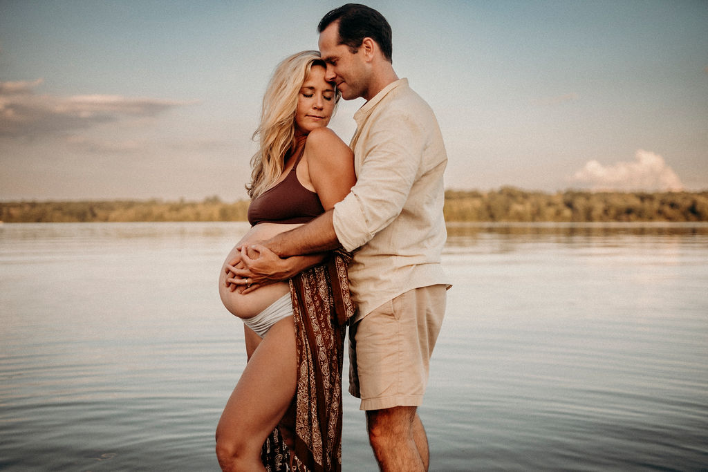 maternity photos of mom and dad by water in lake nockamixin