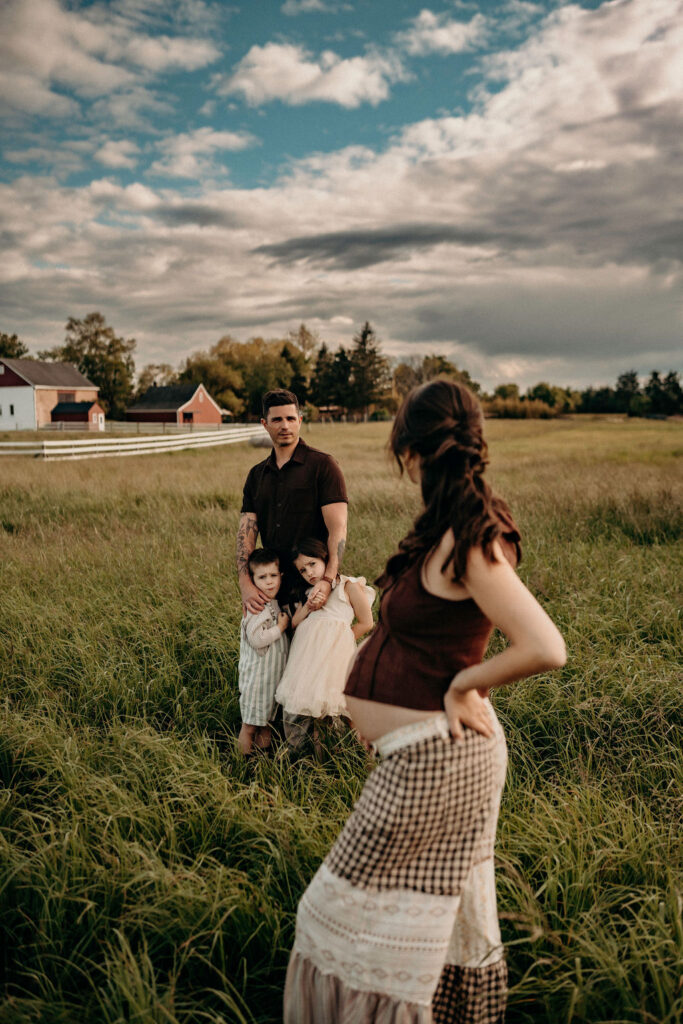 dad looking at pregnant wife at a farm
