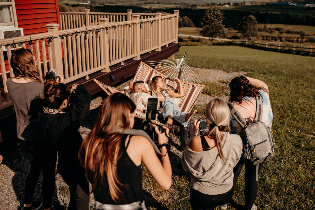 photographers capturing a couple n front of a gorgerous home- perfect for family photographers who want to learn in the lehigh valley PA