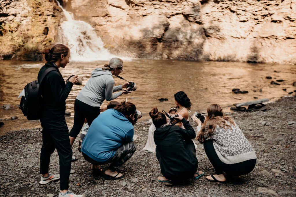 photographers capturing a nursing mother in front of a gorgerous waterfall-- perfect for family photographers who want to learn in the lehigh valley PA